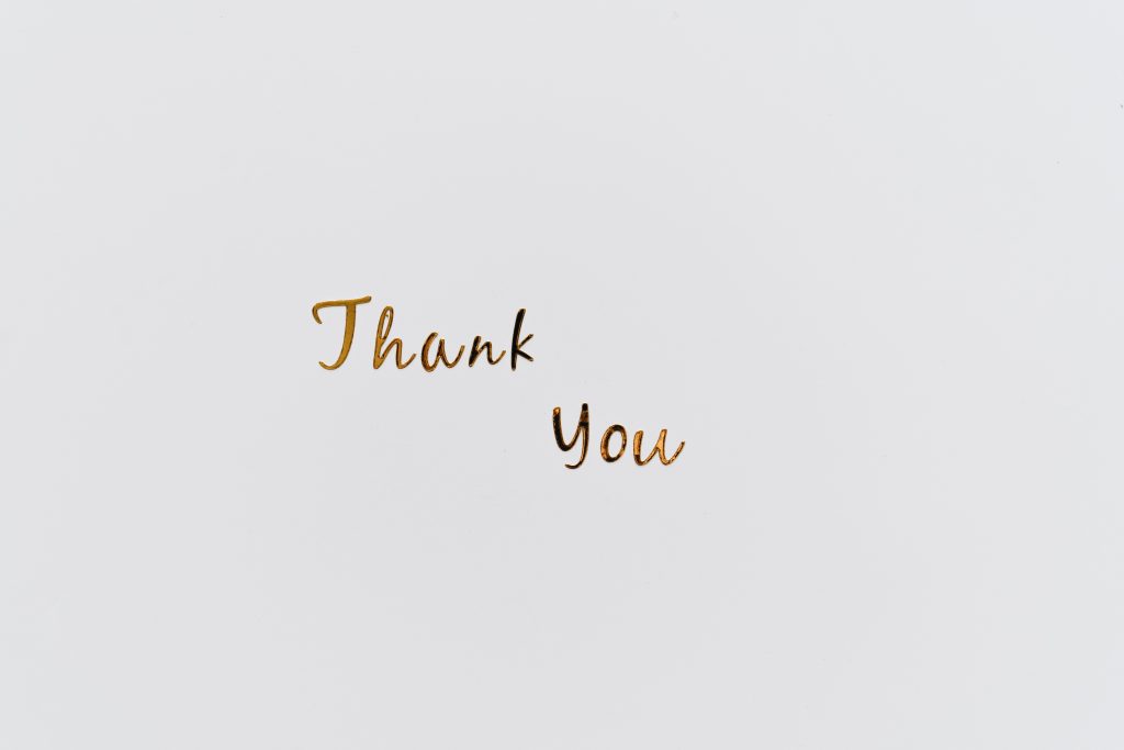 Simple and elegant gold 'Thank You' text on a clean white background, perfect for gratitude cards.